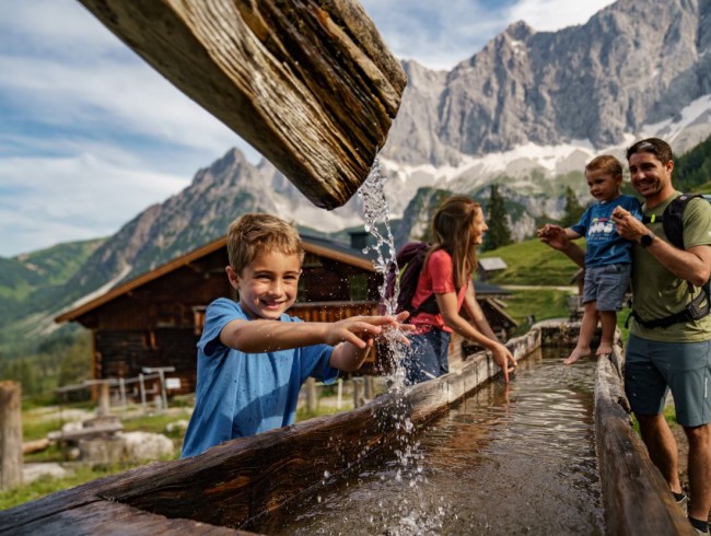 Erfrischen und Abk&uuml;hlen beim Brunnen mit Trinkwasser in der Neustattalm in Ramsau &copy; Schladming-Dachstein_Christine H&ouml;flehner